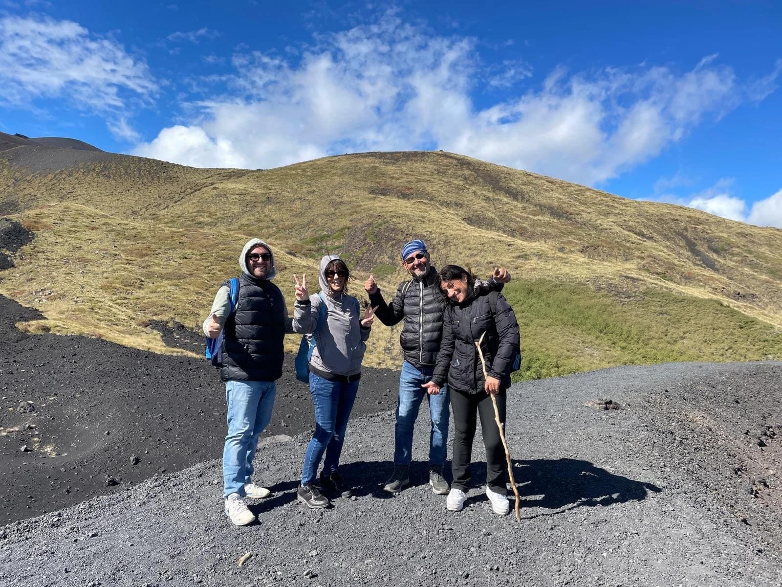 Gruppo in cammino sul sentiero vulcanico sotto un cielo limpido