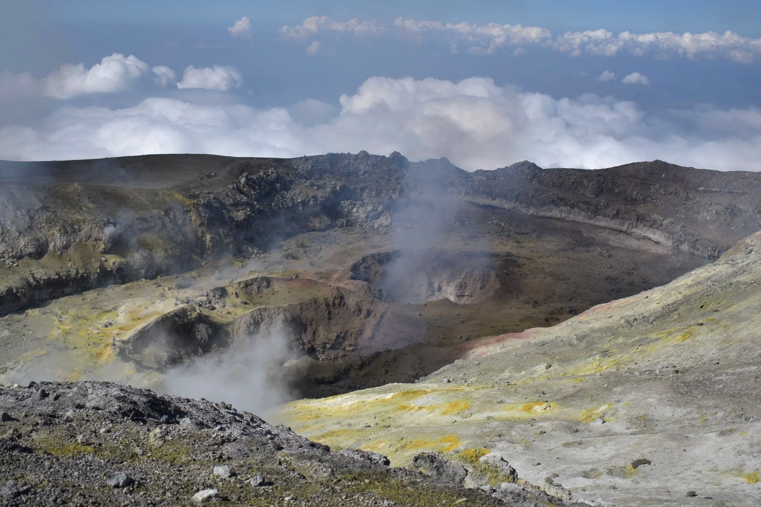 L'interno di un cratere sommitale con fumarole e nuvole basse